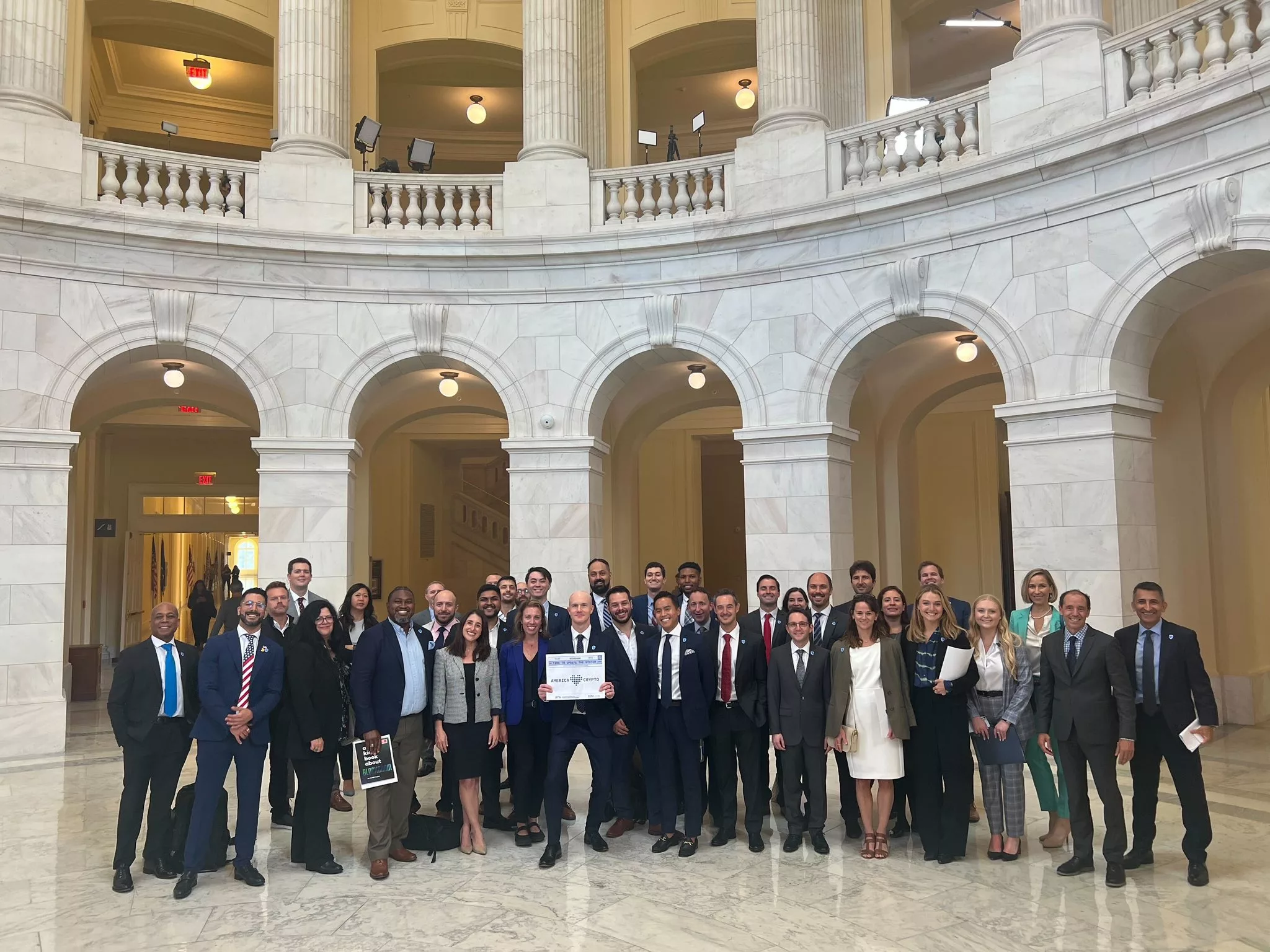 Brian Armstrong in Washington DC holding a 'America Loves Crypto' placard, Sep 2023